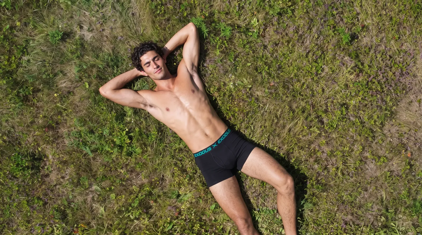 Man lying in a field of wild grass wearing the Goshen Boxer Brief
